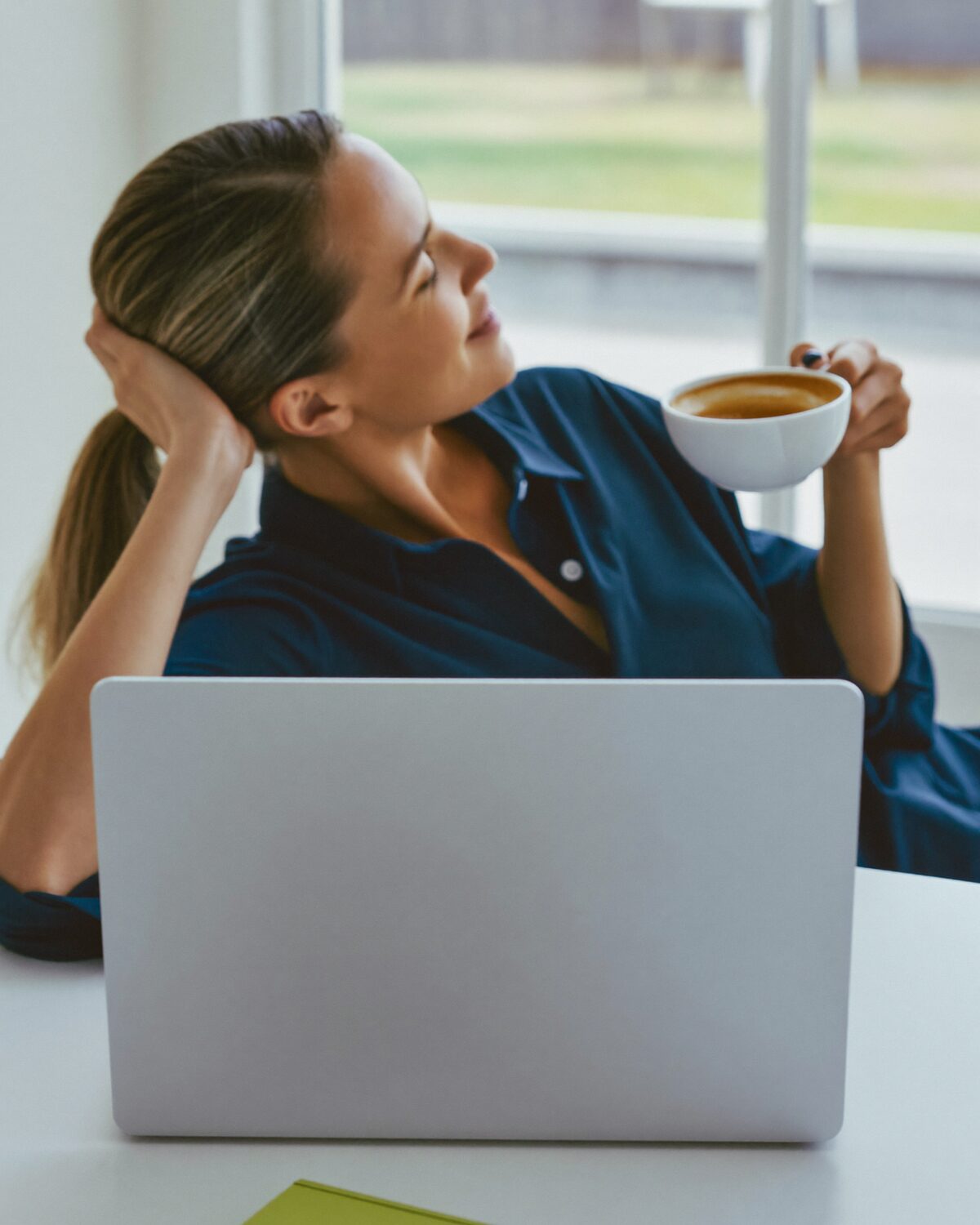 Entspannte Professional lehnt sich mit Kaffee zurück – die LinkedIn-Arbeit ist bereits erledigt